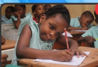 Child taking a test by writing in class